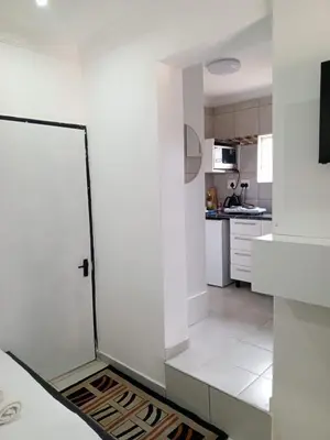 a white kitchen with a door in a room at Millenium Manor in Centurion