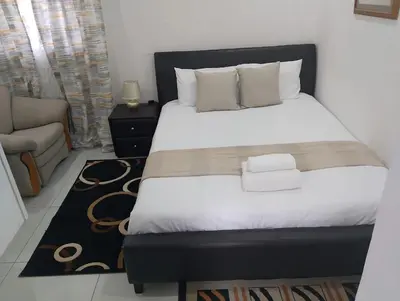 a bedroom with a large bed and a couch at Millenium Manor in Centurion