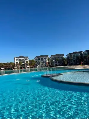 a swimming pool with blue water and buildings in the background at Lagoon lounge - The blyde crystal Lagoon in Pretoria
