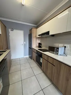 a kitchen with wooden cabinets and a white counter top at Lagoon lounge - The blyde crystal Lagoon in Pretoria