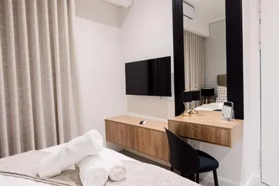 a hotel room with a bed and a desk with a television at 532 Menlyn Maine in Pretoria