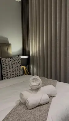 a pile of towels sitting on top of a bed at 532 Menlyn Maine in Pretoria