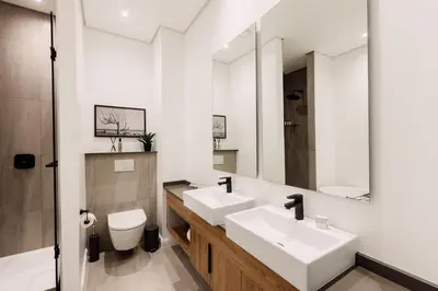 a bathroom with two sinks and a toilet at 532 Menlyn Maine in Pretoria