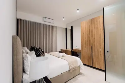a bedroom with a bed and a table and a sliding door at 532 Menlyn Maine in Pretoria