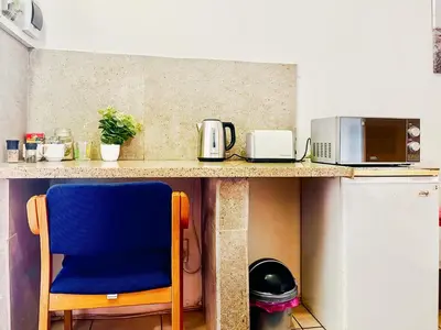 a blue chair sitting next to a kitchen counter at Tiny Home in Centurion