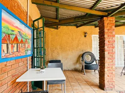 a patio with a white table and a brick wall at Tiny Home in Centurion