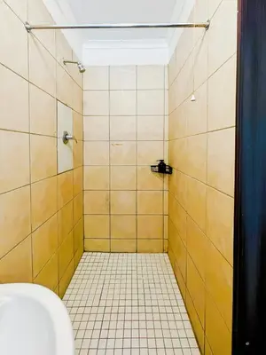 a bathroom with a tiled shower with a toilet at Tiny Home in Centurion