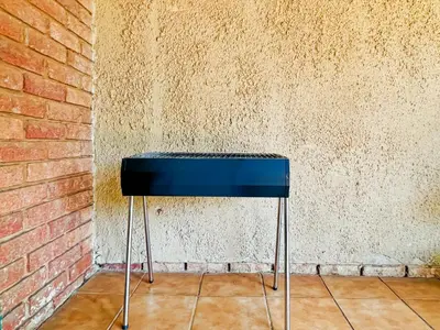 a black stool against a brick wall at Tiny Home in Centurion