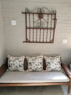 a bench in a room with pillows on it at Aloe Thorn Self Catering in White River