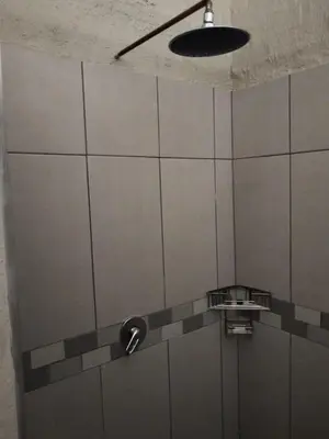 a shower stall with a fan and a light at Aloe Thorn Self Catering in White River