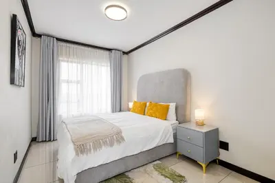 a bedroom with a large bed and a window at TruVela Executive Apartments - Midrand in Midrand