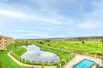 an aerial view of a pool and grassy field at TruVela Executive Apartments - Midrand in Midrand