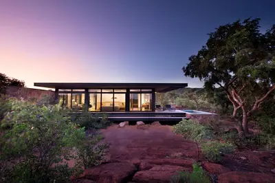 a house in the bush with large windows at 57 Waterberg in Welgevonden Game Reserve
