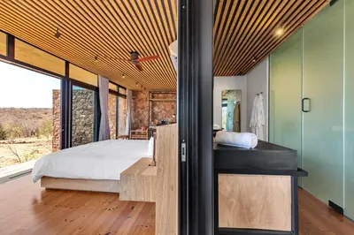 a bedroom with a bed and a large window at 57 Waterberg in Welgevonden Game Reserve