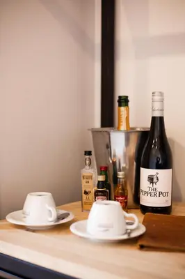 two cups on a counter with a bottle of wine at 57 Waterberg in Welgevonden Game Reserve