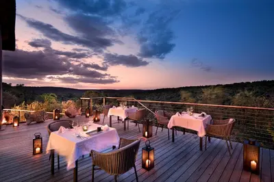 a restaurant with tables and chairs on a deck at 57 Waterberg in Welgevonden Game Reserve