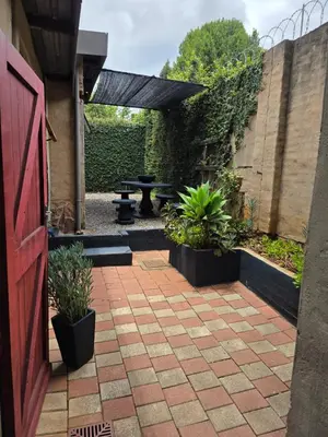 a patio with a picnic table and potted plants at The Pot in Pretoria