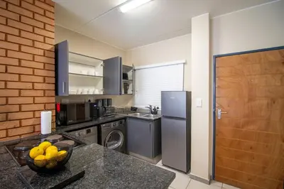 a kitchen with a refrigerator and a counter top at Waterfall Ridge Luxurious Apartment 2 Backup Power in Midrand