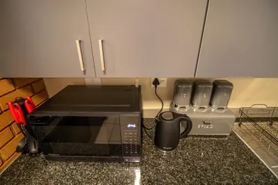 a kitchen counter with a microwave and a coffee maker at Waterfall Ridge Luxurious Apartment 2 Backup Power in Midrand