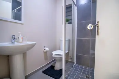 a bathroom with a toilet and a sink and a shower at Waterfall Ridge Luxurious Apartment 2 Backup Power in Midrand