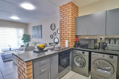a kitchen with a washer and dryer in a room at Waterfall Ridge Luxurious Apartment 2 Backup Power in Midrand