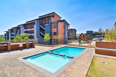 a large swimming pool in front of a building at Waterfall Ridge Luxurious Apartment 2 Backup Power in Midrand