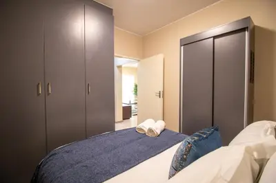 a bedroom with a bed with two towels on it at Waterfall Ridge Luxurious Apartment 2 Backup Power in Midrand