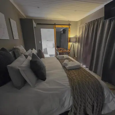 a bedroom with a large bed with pillows at Ratel Katel in Marloth Park