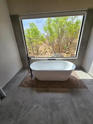 a bath tub in a bathroom with a large window at 19 on Idwala, Mabalingwe Game Reserve in Warmbaths