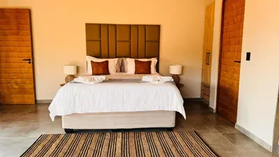 a bedroom with a large bed with white sheets and pillows at 19 on Idwala, Mabalingwe Game Reserve in Warmbaths