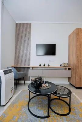 a living room with a tv and a table at Trilogy studio apartment 831 in Pretoria
