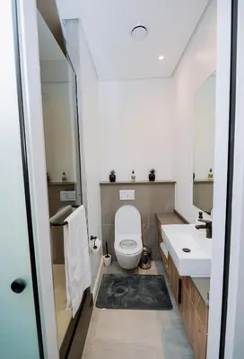 a bathroom with a toilet and two sinks at Trilogy studio apartment 831 in Pretoria