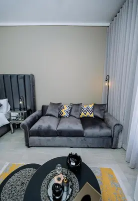a living room with a couch and a table at Trilogy studio apartment 831 in Pretoria