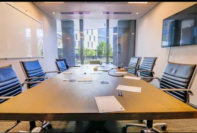 a conference room with a large wooden table and chairs at Trilogy studio apartment 831 in Pretoria