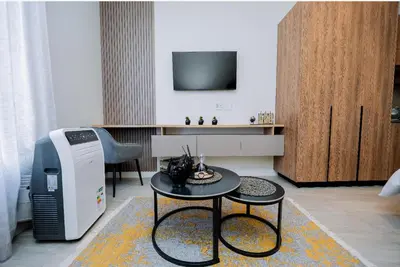 a living room with a small table and a television at Trilogy studio apartment 831 in Pretoria