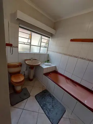 a bathroom with a toilet and a tub and a sink at Eight Martjie Guesthouse in Brits
