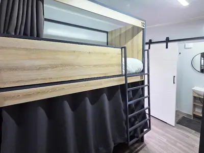 a black bunk bed in a room with a mirror at Beds Inn Midrand in Midrand
