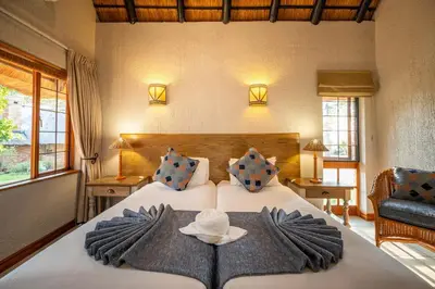 a bedroom with a bed with a hat on it at Kruger Park Lodge Unit No 304 in Hazyview