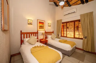 a hotel room with two beds and a window at Kruger Park Lodge Unit No 304 in Hazyview