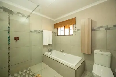 a bathroom with a tub and a toilet and a window at Kruger Park Lodge Unit No 304 in Hazyview