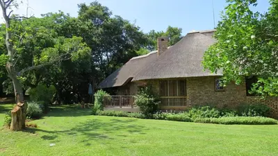 a large brick house with a thatched roof at Kruger Park Lodge Unit No 304 in Hazyview