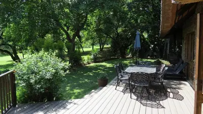 a patio with a table and chairs on a deck at Kruger Park Lodge Unit No 304 in Hazyview