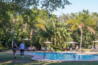 a group of people walking around a swimming pool at Kruger Park Lodge Unit No 304 in Hazyview