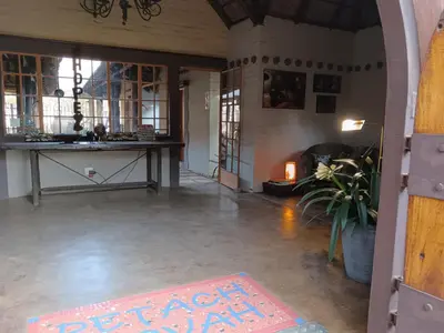 an empty room with a table and a rug on the floor at African Silhouette Guesthouse in Benoni