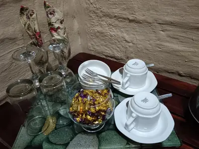 a table with plates and glasses and a tray of food at African Silhouette Guesthouse in Benoni
