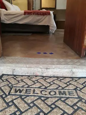 a bed room with a floor with the word mexico on it at African Silhouette Guesthouse in Benoni