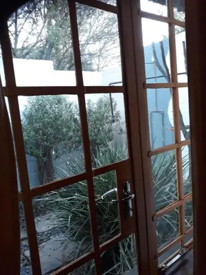 an open door with a view of a garden outside at African Silhouette Guesthouse in Benoni