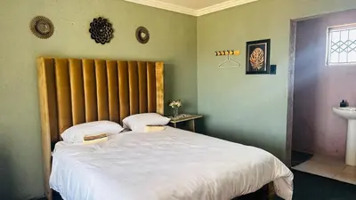 a bedroom with a large bed and a sink at Mahlako Guest Lodge in Polokwane