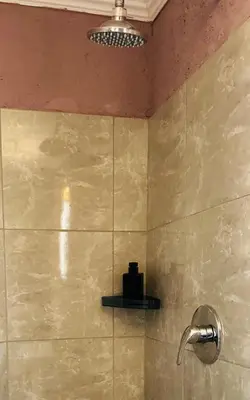 a bathroom with a shower with a shower head at Mahlako Guest Lodge in Polokwane