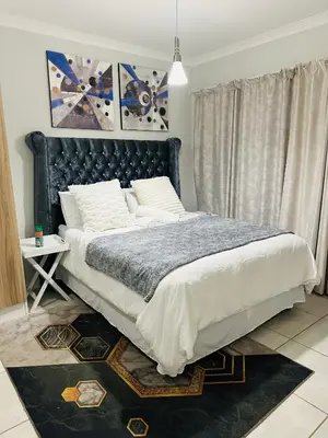a bedroom with a large bed with a black headboard at The Blyde Pretoria in Pretoria
